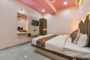 1 dormitorio con 1 cama extragrande y baño en FabHotel Max Inn en Ahmedabad