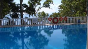 a swimming pool with a white fence and trees at Vigla Village in Spartià