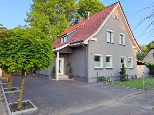 a white house with a red roof at Marica‘s Meereszeiten Wellness in Midlum