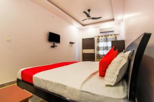 a bedroom with a bed with red and white pillows at Vaibhav Laxmi Paradise in Chinhat