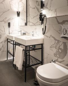 biała łazienka z umywalką i toaletą w obiekcie Hotel Yigitalp Istanbul w Stambule