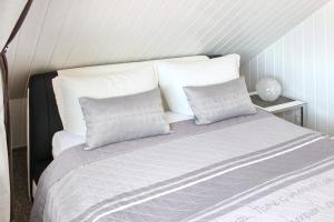 a bed with three pillows on it in a room at Ferienhaus Windspiel in Kleeden