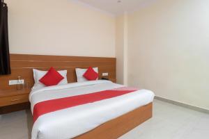 una camera da letto con un letto con cuscini rossi e bianchi di OYO Flagship 45850 Vishwanath Palace Near Alambagh Awadh Chauraha a Charbagh