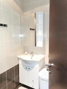 La salle de bains est pourvue d'un lavabo, de toilettes et d'un miroir. dans l'établissement Portofino app, à Izola