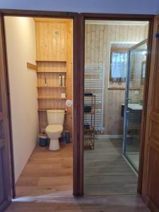 a bathroom with a toilet and a glass door at Aux P'tioux Bonheurs in Le Noyer