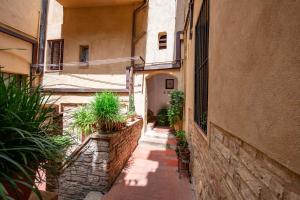 Un callejón con plantas y un edificio. en The secret nest in San Gimignano, en San Gimignano