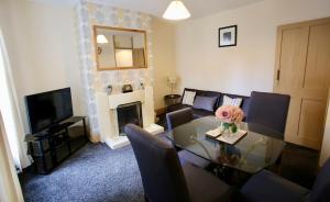 een woonkamer met een glazen tafel en een open haard bij Albemarle House in Taunton