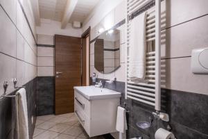 een witte badkamer met een wastafel en een spiegel bij Appartamento Sole 2 in Giurdignano