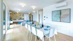 une salle à manger avec une table blanche et des chaises blanches dans l'établissement VILLA VERETIUM 8, Emma Villas, à Borgio Verezzi
