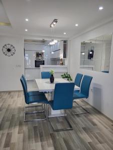 uma sala de jantar com uma mesa branca e cadeiras azuis em Chic and Cozy Apartment on the Main Pedestrian Street em Struga