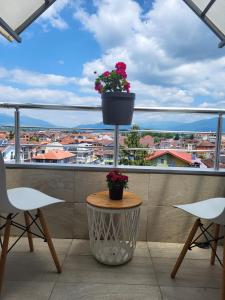a balcony with two chairs and a flower pot on a pole at Chic and Cozy Apartment on the Main Pedestrian Street in Struga