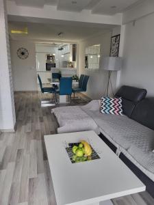 a living room with a couch and a table with fruit on it at Chic and Cozy Apartment on the Main Pedestrian Street in Struga
