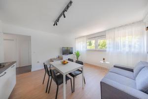 un soggiorno con tavolo e divano blu di Apartment Fani with free private parking a Dubrovnik