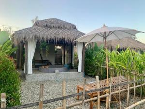 Cabaña con mesa y sombrilla en Waree Onsen Resort en Lamphun