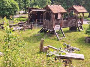 einen Spielplatz mit Pavillon und ein Haus in der Unterkunft Turistická Chata Chopok in Demänovská Dolina