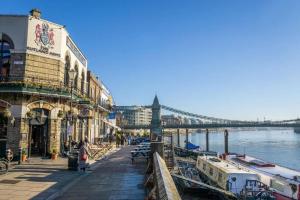 a bridge over a river with buildings and boats at Barnes the village in the centre of London in London