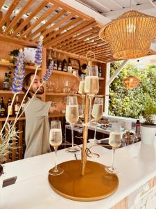 a man standing behind a bar with wine glasses at Hôtel De Londres in Menton