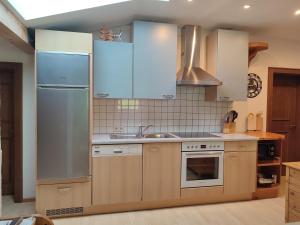 a kitchen with stainless steel appliances and wooden cabinets at Haus Enzian in Mittersill