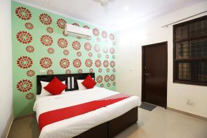 a bedroom with a bed with red pillows on it at OYO Flagship 44151 Royal Guest House in Garhi Harsāru