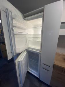 an empty refrigerator with its door open in a room at Exklusive Wohnung Nähe Frankfurt in Eppstein