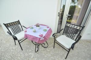 een tafel met twee stoelen en een tafel met een roze tafelkleed bij Boat dreams , garden relax in Matino