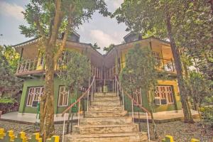 Una casa con escaleras que conducen a ella. en Hotel O 46691 Jaldapara Rhino Resort, en Alīpur Duār