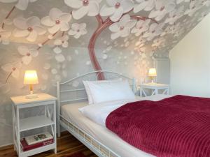 a bedroom with a bed with a tree mural on the wall at Ferienwohnung Heidehummel in Lübbenau