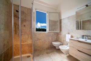 a bathroom with a shower and a toilet and a sink at S' Agrùstu in Orosei