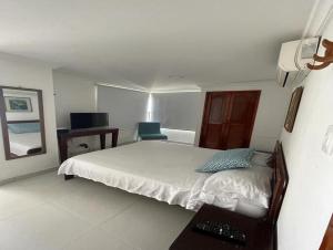 a bedroom with a bed and a desk with a keyboard at Rivas Apartamentos Cartagena in Cartagena de Indias