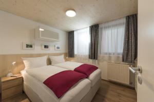 Un dormitorio con una cama grande y una ventana en Ferienwohnungen Nachbaur en Oberjoch