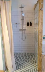 La salle de bains est pourvue d'une douche et de carrelage noir et blanc. dans l'établissement Quartier Romantikum, à Güssing