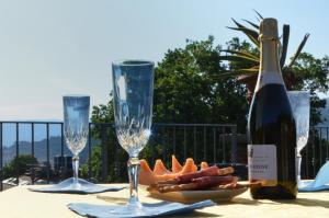 Maison Brinati Bed and Breakfast في مونسومانو: طاولة مع كأسين وزجاجة من النبيذ