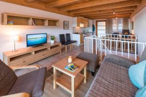 ein Wohnzimmer mit einem Sofa und einem TV in der Unterkunft Ferienwohnungen Nachbaur in Oberjoch