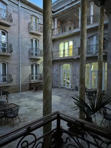 een lege binnenplaats van een gebouw met een balkon bij Prestige Terrace Hotel in Bukhara