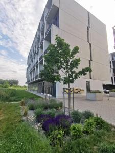 a building with a tree in front of it at Travel&Sleep Airport Apartment Zarembowicza in Wrocław