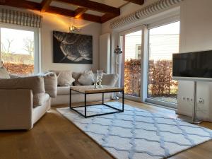 a living room with a couch and a tv at HofGut Bockelkathen Apartment 8 in Lüdersburg