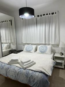 a bedroom with a large bed with towels on it at הפינה בנחל in Hagoshrim