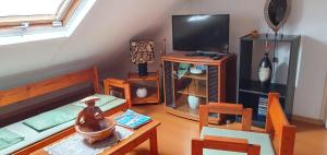 ein Wohnzimmer mit einem Bett und einem TV in der Unterkunft Chez Mimose et Henri in Saint-Benoît