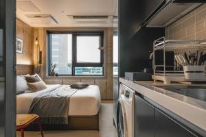 une chambre d'hôtel avec un lit et une cuisine dans l'établissement Urbanstay Boutique Nampo BIFF, à Busan