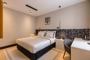 Cora Hotel في سبليت: غرفة فندقية بها سرير كبير ومكتب