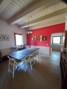 a dining room with a table and a red wall at Casa Rosa in San Costanzo