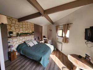 1 dormitorio con 1 cama y TV. en Les chambres du Bonheur, en Fontaine-sous-Jouy