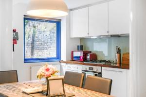 une cuisine avec une table et des chaises ainsi qu'une fenêtre dans l'établissement Spacious 2 bedroom Apartment in Camden, à Londres
