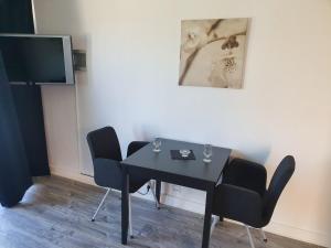 Habitación con mesa con sillas y TV. en Hotell Dalsland, en Ed