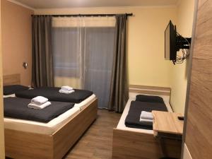 una camera con due letti e una televisione di AlpenKlub Hotel a Vordernberg