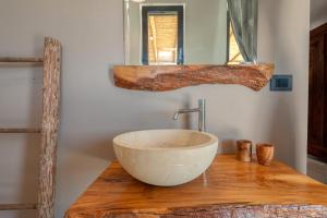 a bathroom with a bowl sink on a wooden counter at La casa di Rollo in Otranto +15 photos