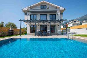 a house with a swimming pool in front of a house at Villa Bahar Lux Oludeniz in Fethiye