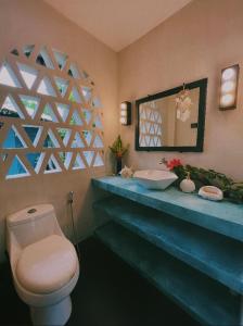 W łazience znajduje się toaleta, umywalka i lustro. w obiekcie Secret Pool Villa Tuason Beach w mieście General Luna