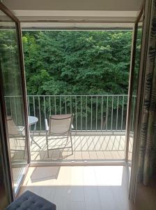 eine abgeschirmte Veranda mit 2 Stühlen und einem Tisch in der Unterkunft Marel-Apartments Willa Fonte - apartament 8 in Polanica-Zdrój