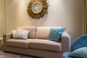 Residence Lungomare - Charming apartments في ريتشيوني: غرفة معيشة مع أريكة ومرآة